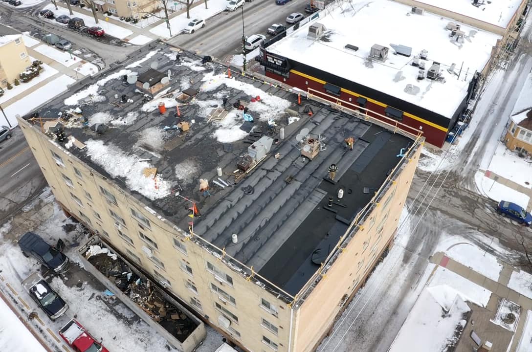 A snowy commercial roof under construction