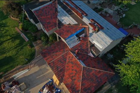 View of workers tiling roof from above the roof 